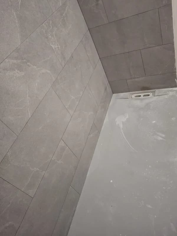 Zona de ducha con alicatado gris y plato de ducha blanco — Junior Reformas