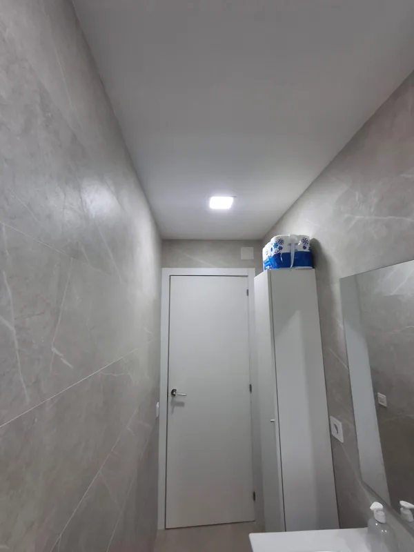 Baño con revestimiento porcelánico gris en paredes y suelo — Junior Reformas