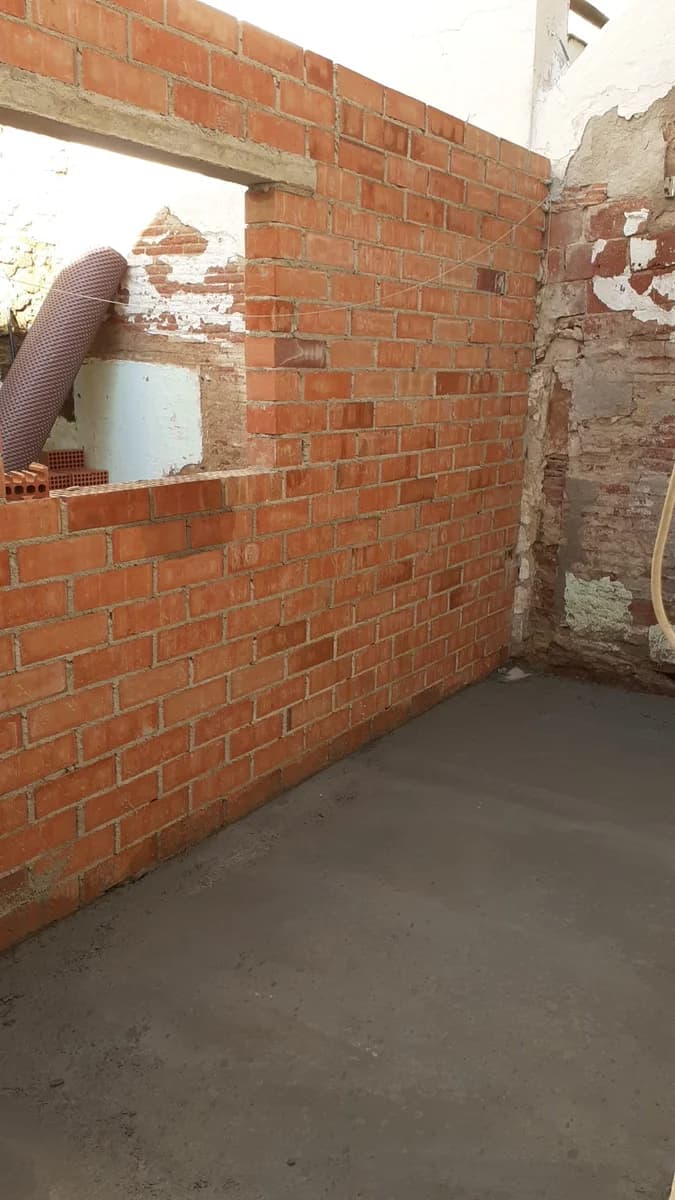 Obra en curso: construcción pared ladrillo — Junior Reformas