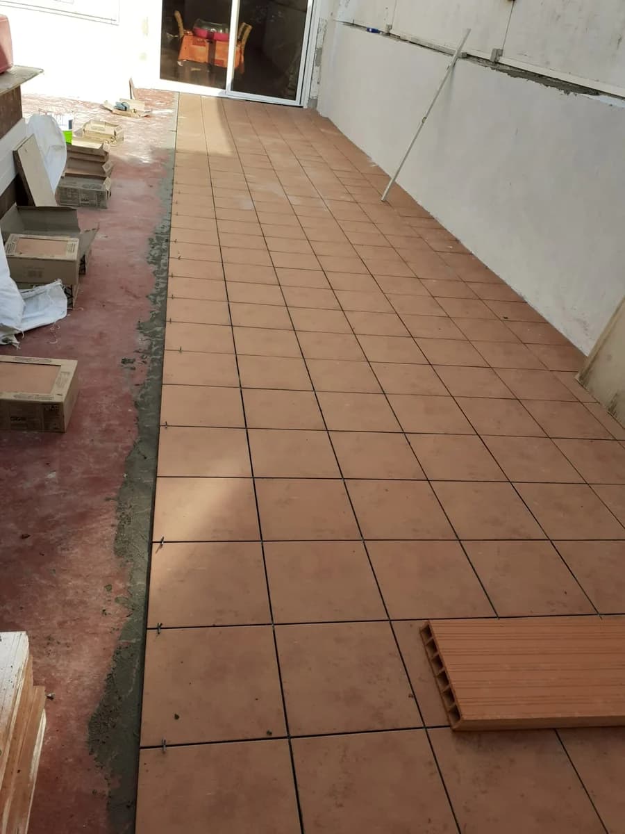 Exterior en curso: instalación azulejos terracota terraza — Junior Reformas