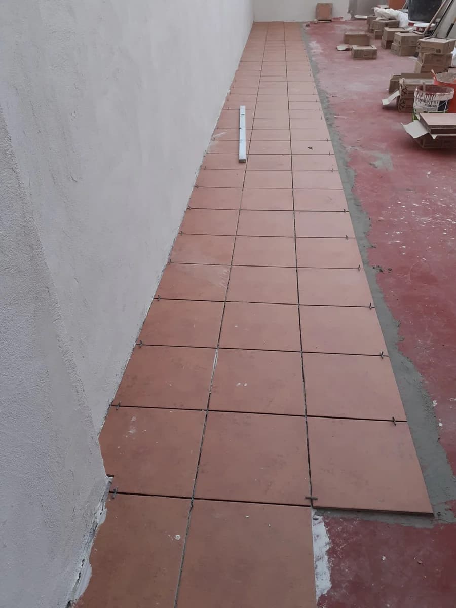Exterior en curso: instalación azulejos terracota terraza — Junior Reformas