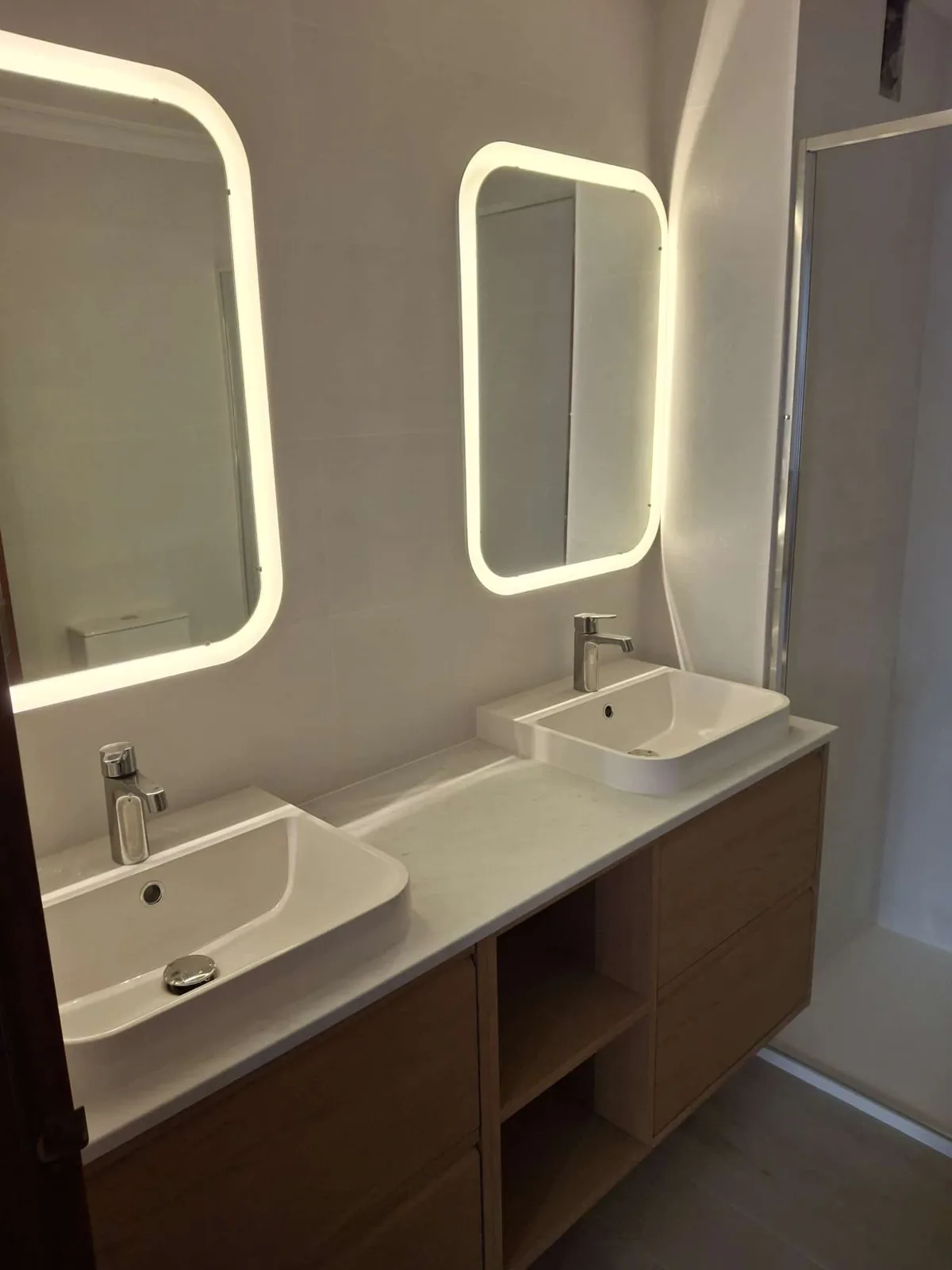 Baño con mueble de doble lavabo y espejos con luz LED integrada — Junior Reformas