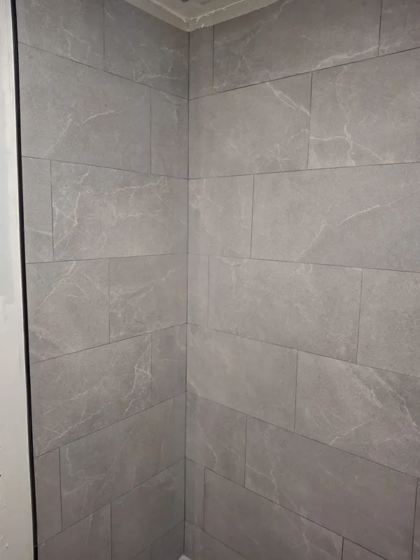 Transformación de ducha: alicatado en obra y acabado final en porcelánico gris — acabado final — Junior Reformas