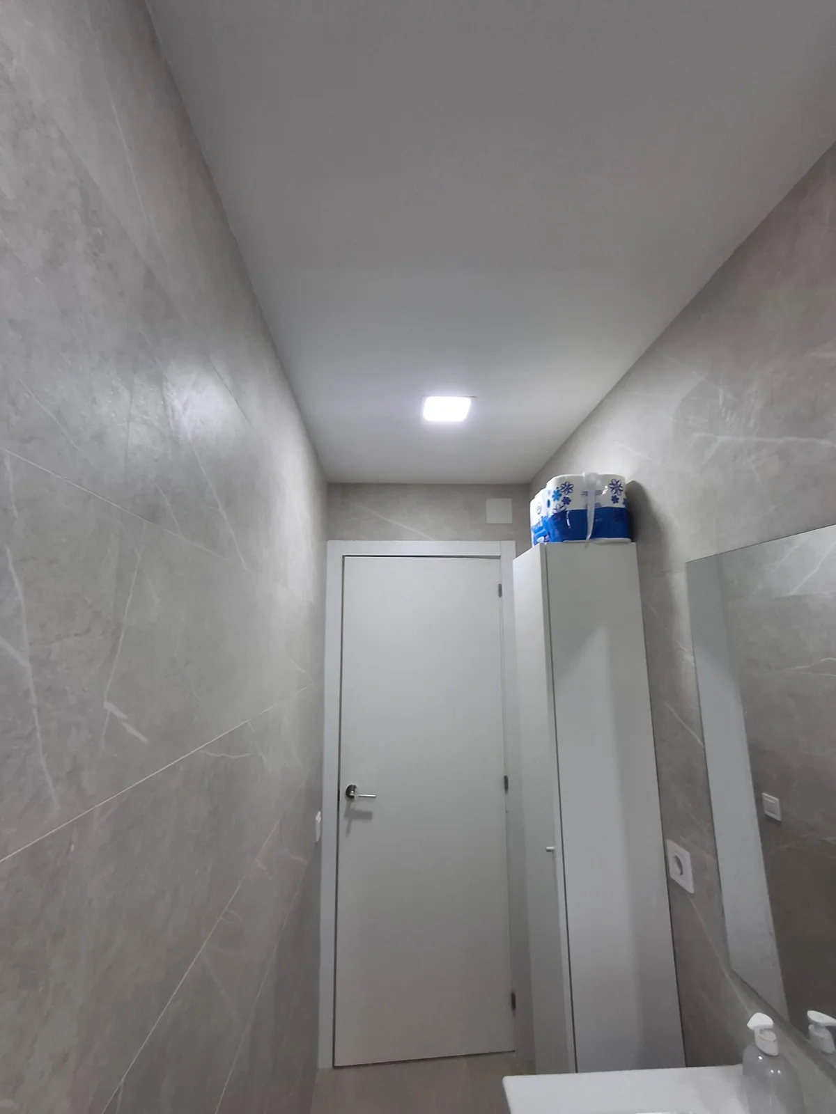 Baño con revestimiento porcelánico gris en paredes y suelo — Junior Reformas