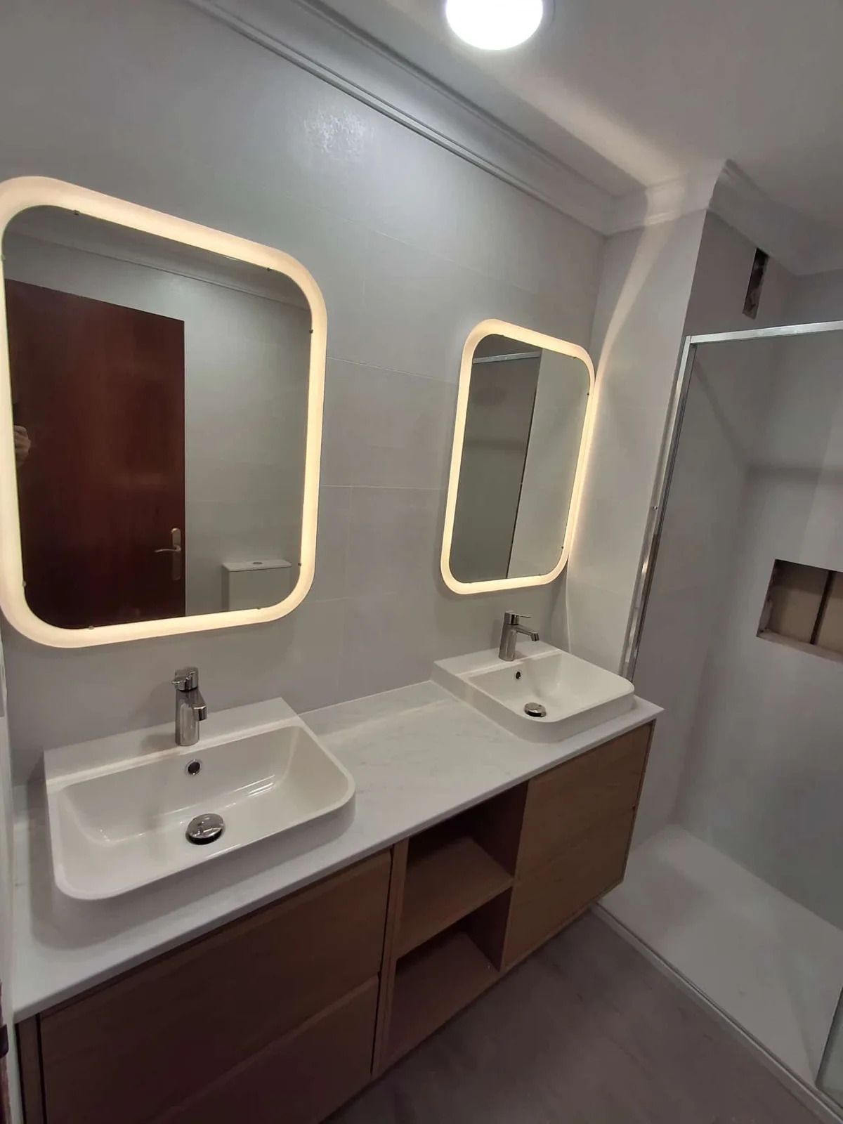 Baño moderno con doble espejo retroiluminado LED y ducha a ras — Junior Reformas