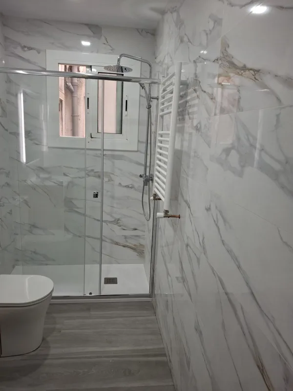 De obra en curso a baño terminado con ducha a ras de suelo — acabado final — Junior Reformas