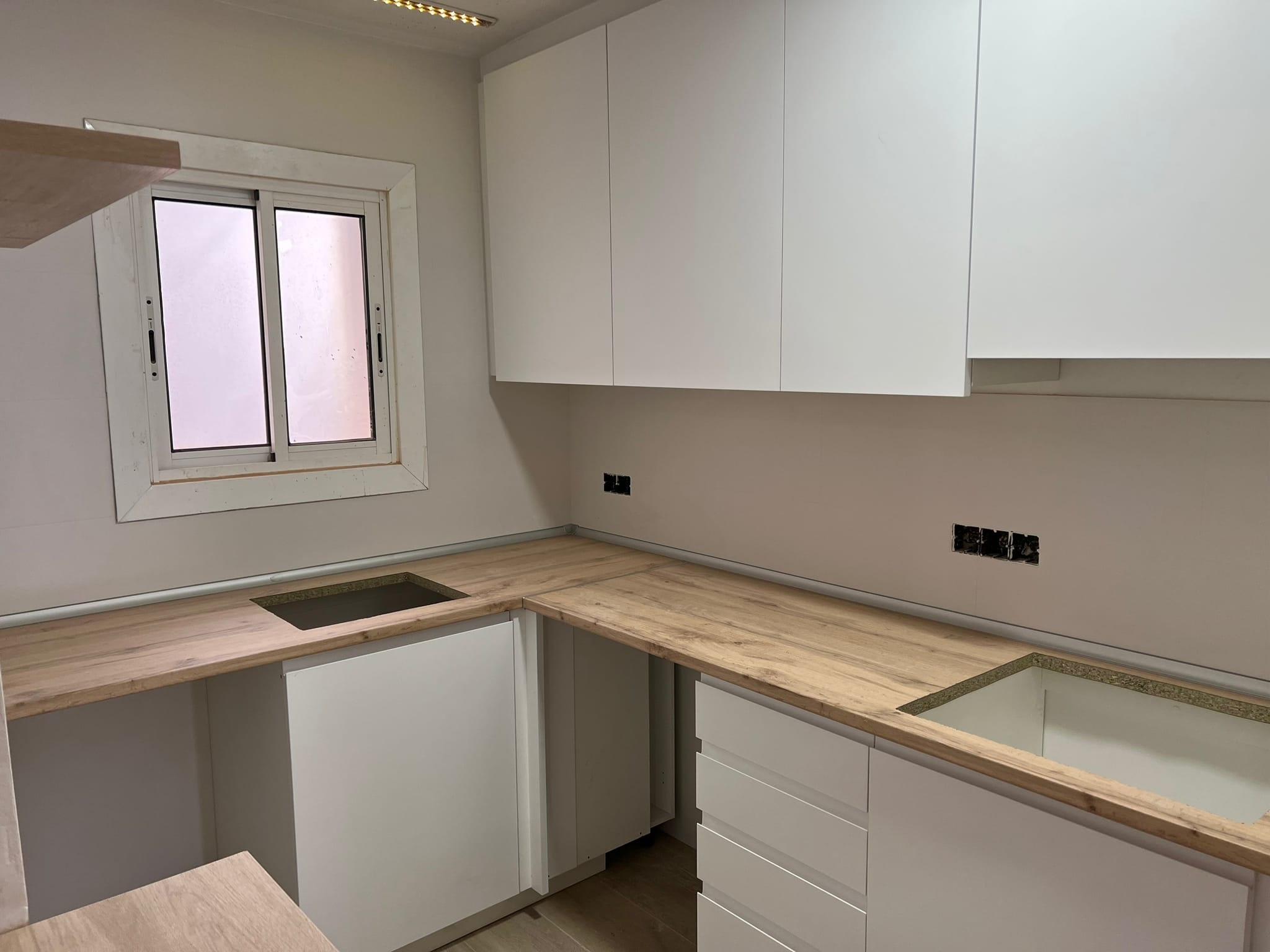 Cocina blanca con encimera de madera