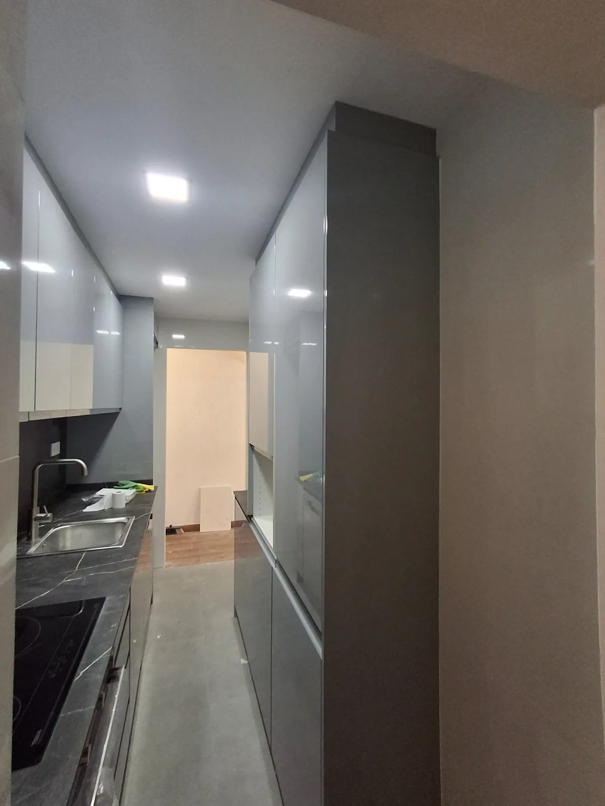 Pasillo de piso reformado con cocina integrada e iluminación LED en techo — Junior Reformas